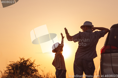 Image of Father and son playing in the park at the sunset time.