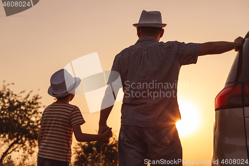 Image of Father and son playing in the park at the sunset time.