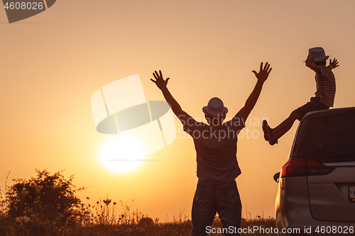 Image of Father and son playing in the park at the sunset time.