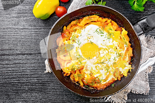 Image of Scrambled eggs with vegetables in pan on board top