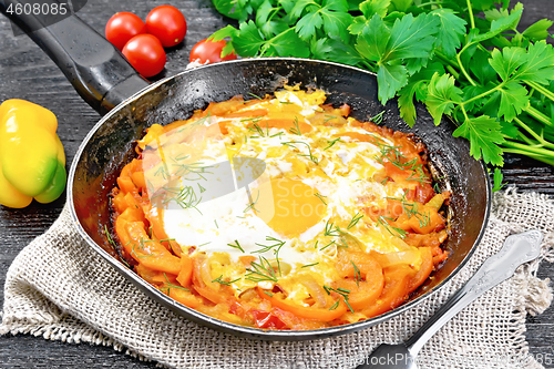 Image of Scrambled eggs with vegetables in pan on board