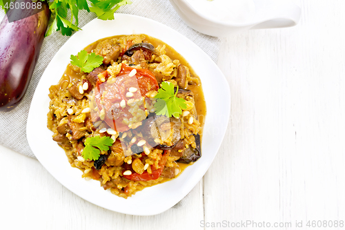 Image of Rice with vegetables and chicken in plate on light board top