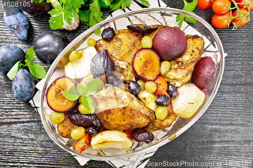 Image of Chicken with fruits and tomatoes in glass pan on board top