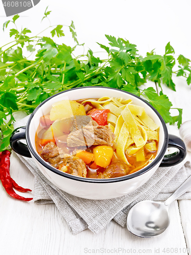 Image of Lagman in bowl on wooden board