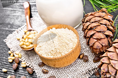 Image of Flour cedar in bowl with nuts on dark wooden board