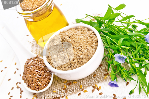 Image of Flour linen in bowl with seeds and oil on wooden board