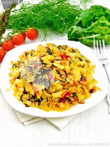 Image of Cabbage stew with chard in plate on light wooden board