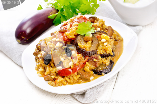 Image of Rice with vegetables and chicken in plate on light wooden board