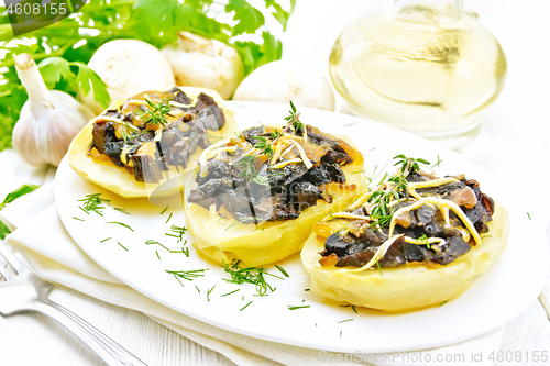 Image of Potatoes stuffed with mushrooms on wooden board