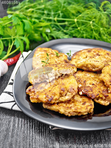 Image of Fritters meat in black plate on dark board