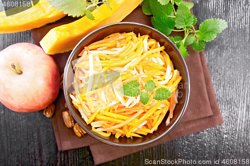 Image of Salad of pumpkin and apple in bowl on dark board top