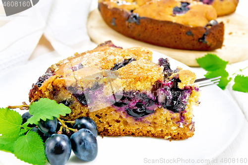 Image of Pie with black grapes  in plate on light board