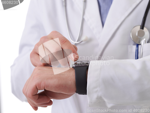 Image of doctor using smartwatch while checking heartbeat pulse