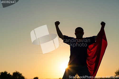 Image of One man playing superhero at the sunset time