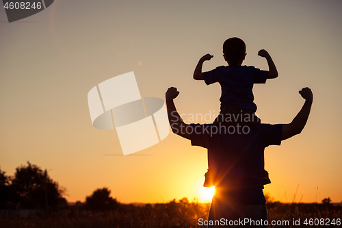 Image of Father and son playing in the park at the sunset time.