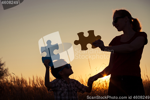 Image of Mother and son playing at the park at the sunset time. 