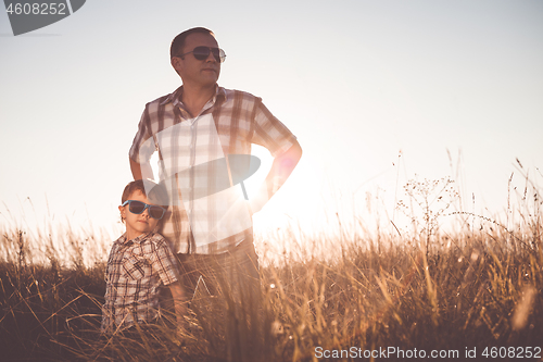 Image of Father and son playing on the field at the day time.