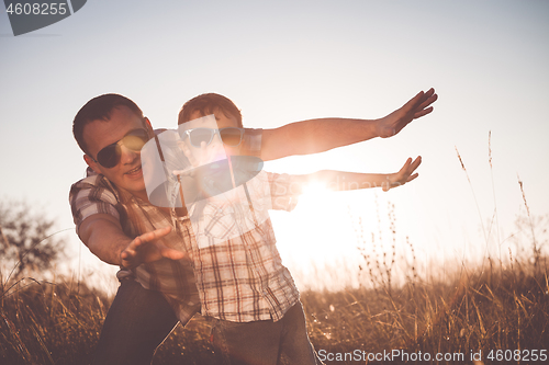 Image of Father and son playing in the park at the day time.