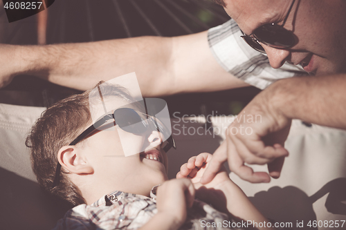 Image of Father and son playing in the park at the day time.