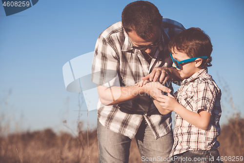 Image of Father and son playing in the park at the day time.