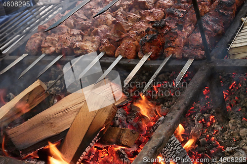 Image of Pieces of meat are roasted on metal bars