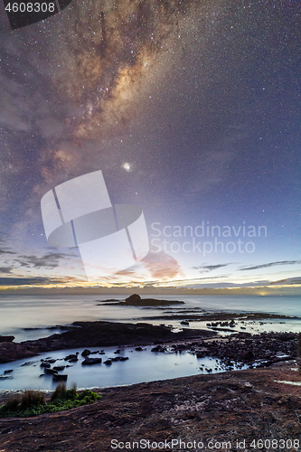 Image of Starry night sky just before sunrise of coastal landscape