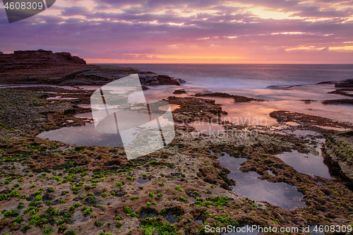 Image of Coastal dawn skies at low tide exposing the rocky reef