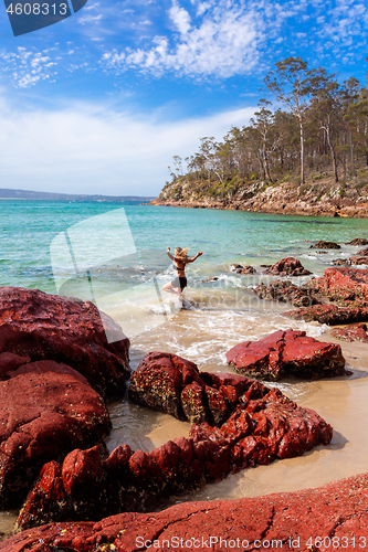 Image of Woman playing in ocean paradise beach travel destination