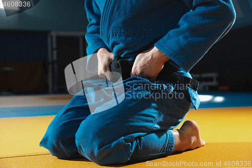 Image of Young judo fighter in kimono posing comfident in the gym, strong and healthy