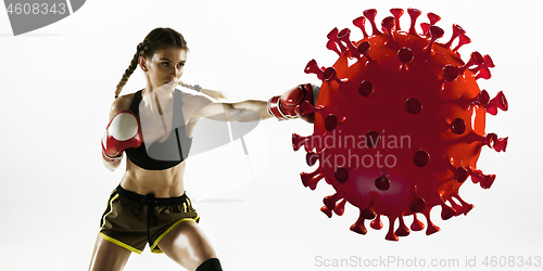 Image of Professional sportswoman kicking, punching coronavirus model - fight the desease, flyer