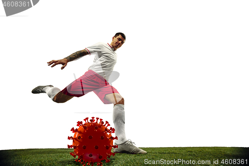 Image of Football or soccer player kicking, punching model of coronavirus - fighting with epidemic concept