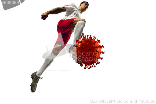 Image of Football or soccer player kicking, punching model of coronavirus - fighting with epidemic concept