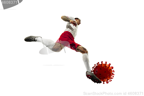 Image of Football or soccer player kicking, punching model of coronavirus - fighting with epidemic concept