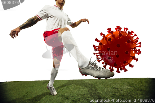 Image of Football or soccer player kicking, punching model of coronavirus - fighting with epidemic concept