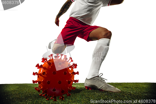 Image of Football or soccer player kicking, punching model of coronavirus - fighting with epidemic concept