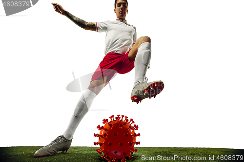 Image of Football or soccer player kicking, punching model of coronavirus - fighting with epidemic concept