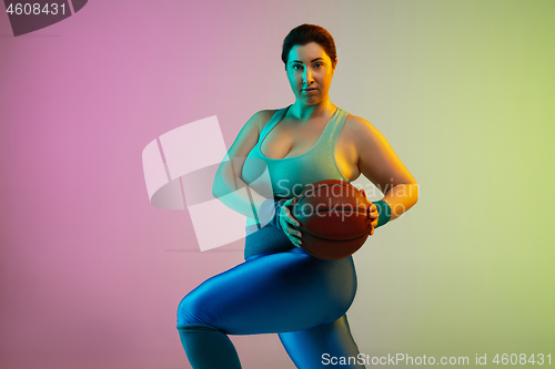 Image of Young caucasian plus size female model\'s training on gradient purple green background