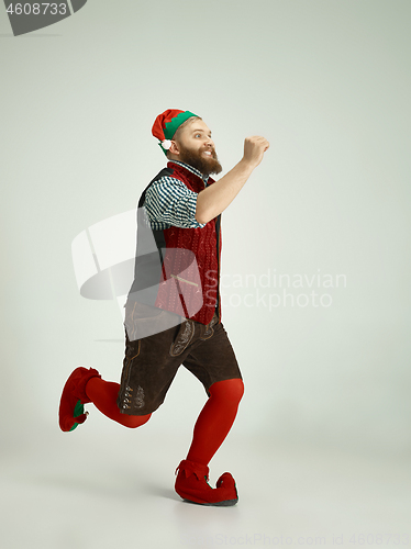 Image of friendly man dressed like a funny gnome posing on an isolated gray background