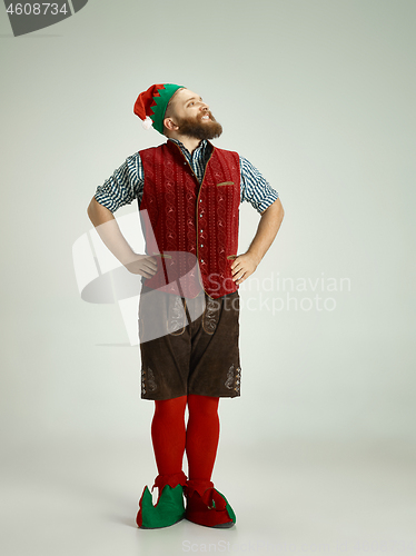 Image of friendly man dressed like a funny gnome posing on an isolated gray background