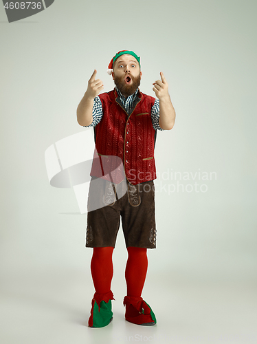 Image of friendly man dressed like a funny gnome posing on an isolated gray background