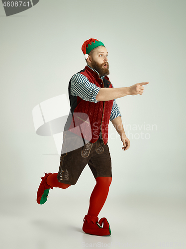 Image of friendly man dressed like a funny gnome posing on an isolated gray background