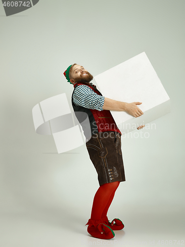 Image of friendly man dressed like a funny gnome posing on an isolated gray background