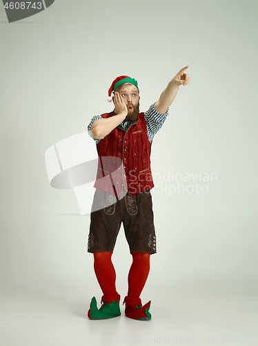 Image of friendly man dressed like a funny gnome posing on an isolated gray background