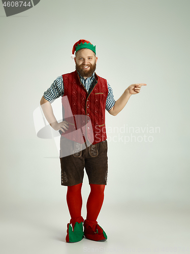 Image of friendly man dressed like a funny gnome posing on an isolated gray background