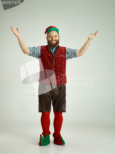 Image of friendly man dressed like a funny gnome posing on an isolated gray background