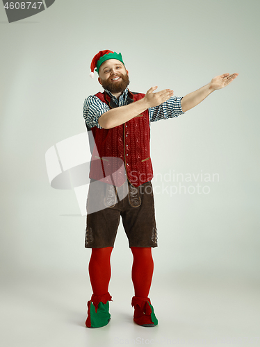 Image of friendly man dressed like a funny gnome posing on an isolated gray background