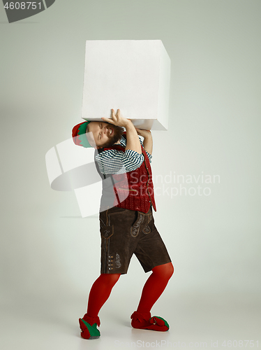 Image of friendly man dressed like a funny gnome posing on an isolated gray background