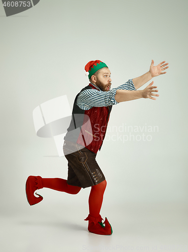 Image of friendly man dressed like a funny gnome posing on an isolated gray background