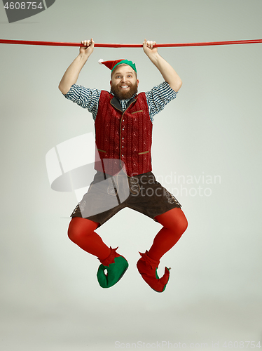 Image of friendly man dressed like a funny gnome posing on an isolated gray background