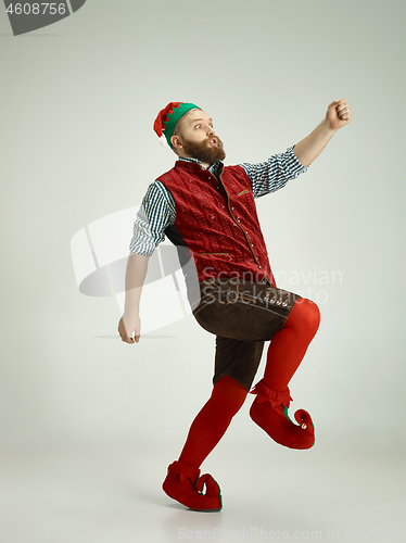 Image of friendly man dressed like a funny gnome posing on an isolated gray background